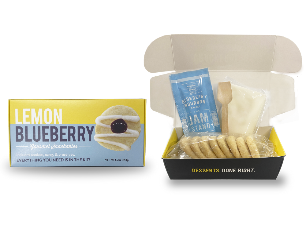A packaged snackable lemon blueberry crackerology kit which includes cookies, icing, and jam displayed both outside and inside an open box.